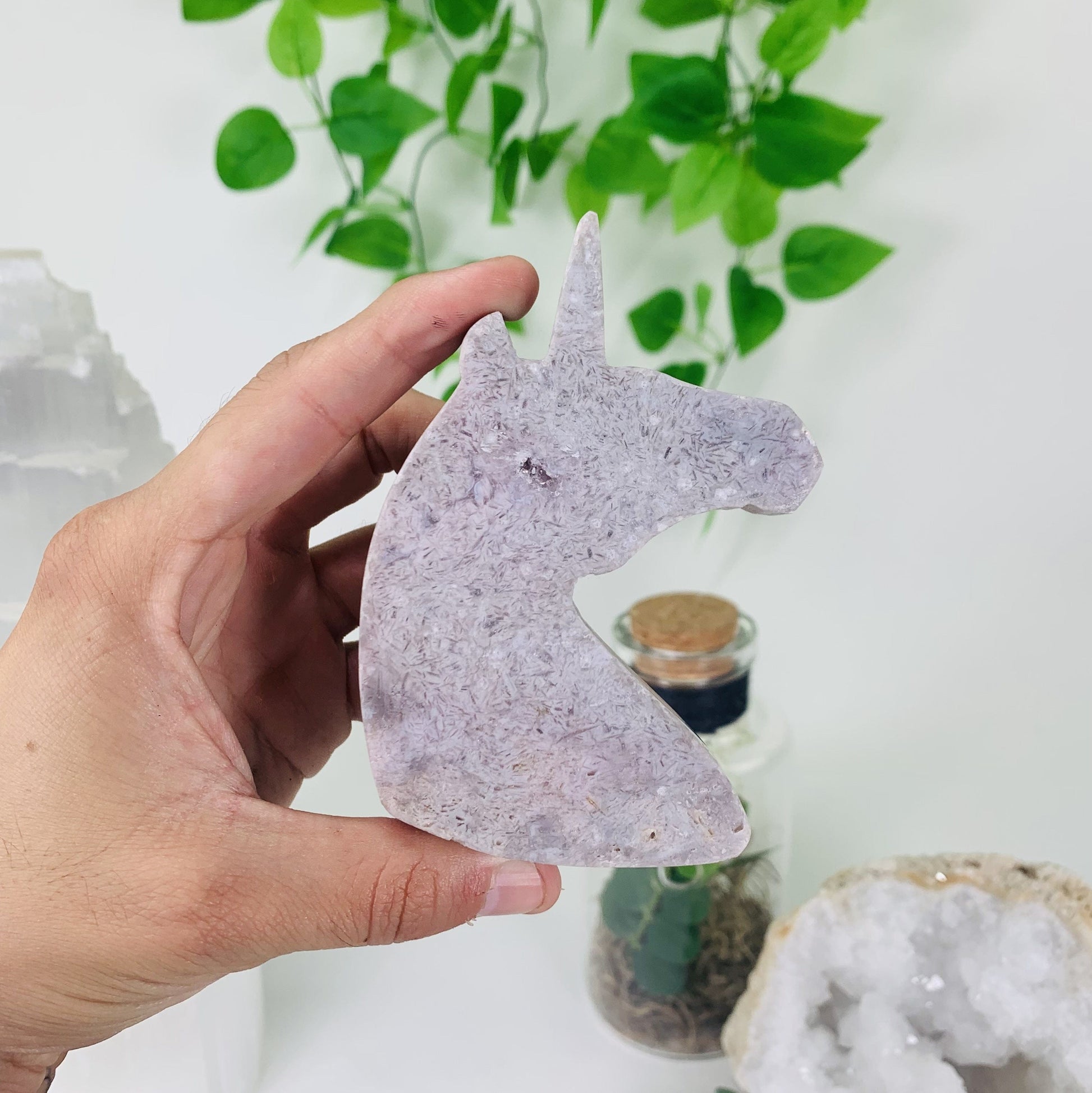 Picture of Pink amethyst horse being held for size reference.