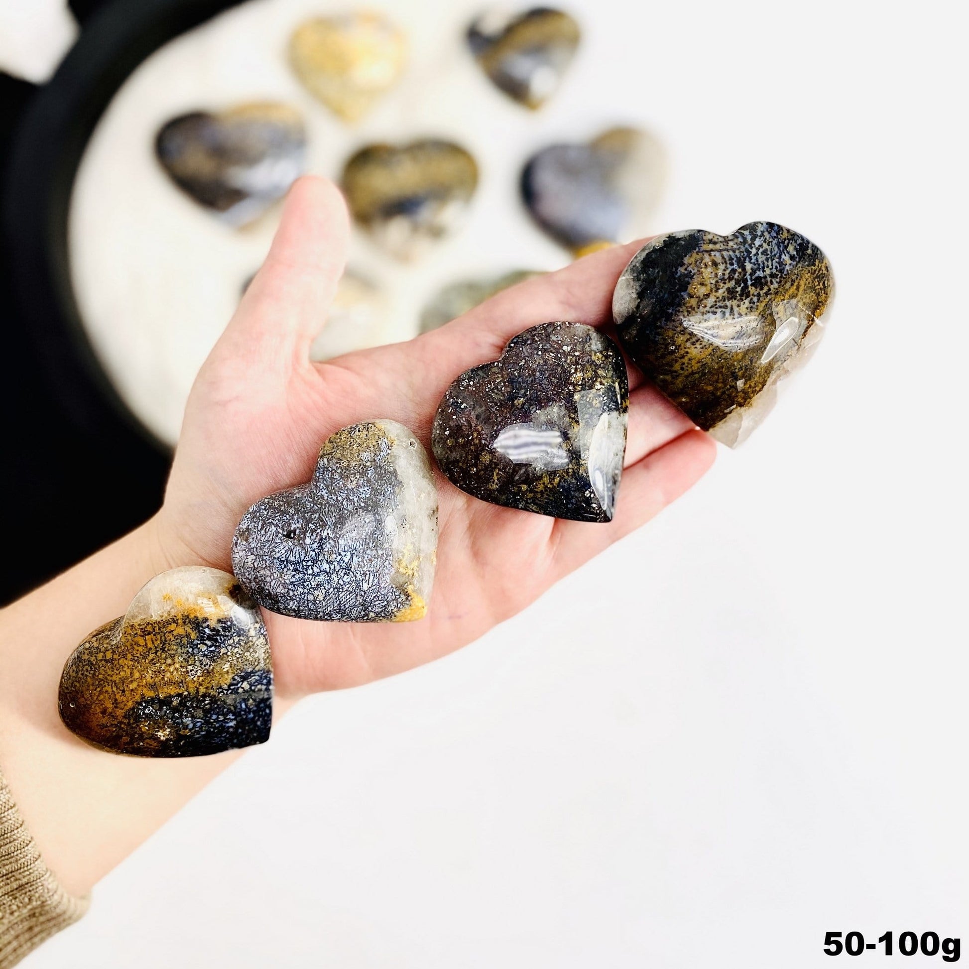 hand holding up 50-100g lions eye jasper hearts