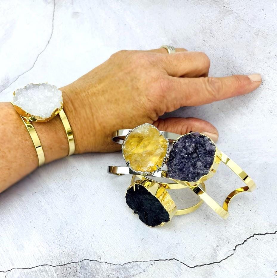 3 stone bracelets next to a hand