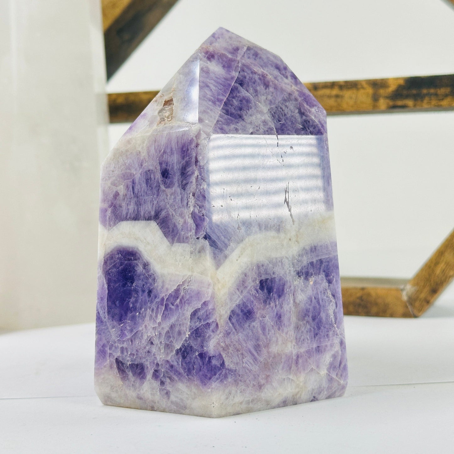 chevron amethyst polished point with decorations in the background