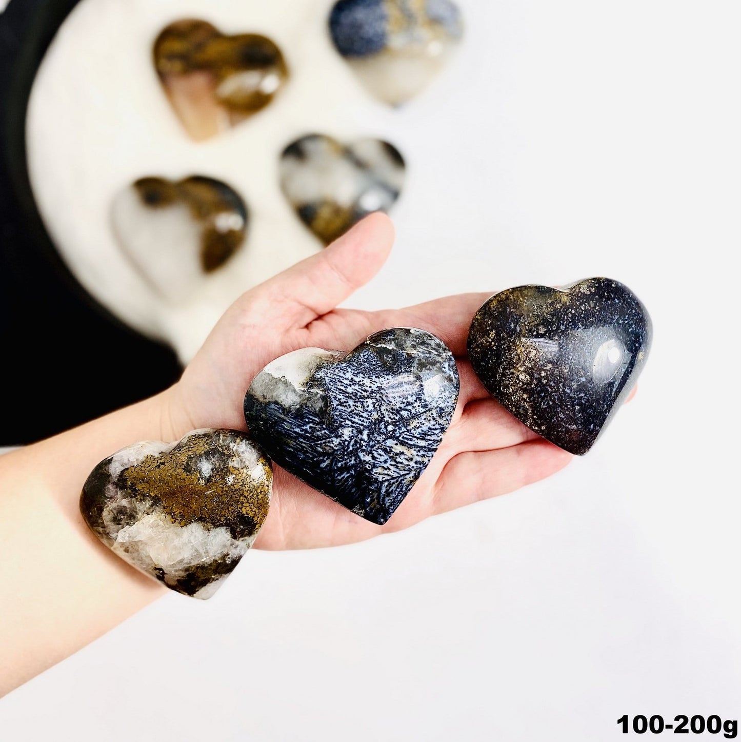 hand holding up 100-200g lions eye jasper hearts 