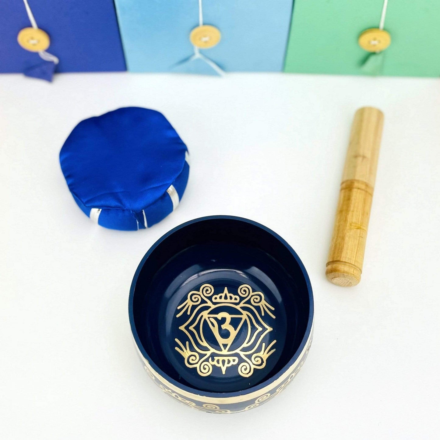 Brass Tibetan  throat Chakra Singing Bowl next to the pillow and mallot