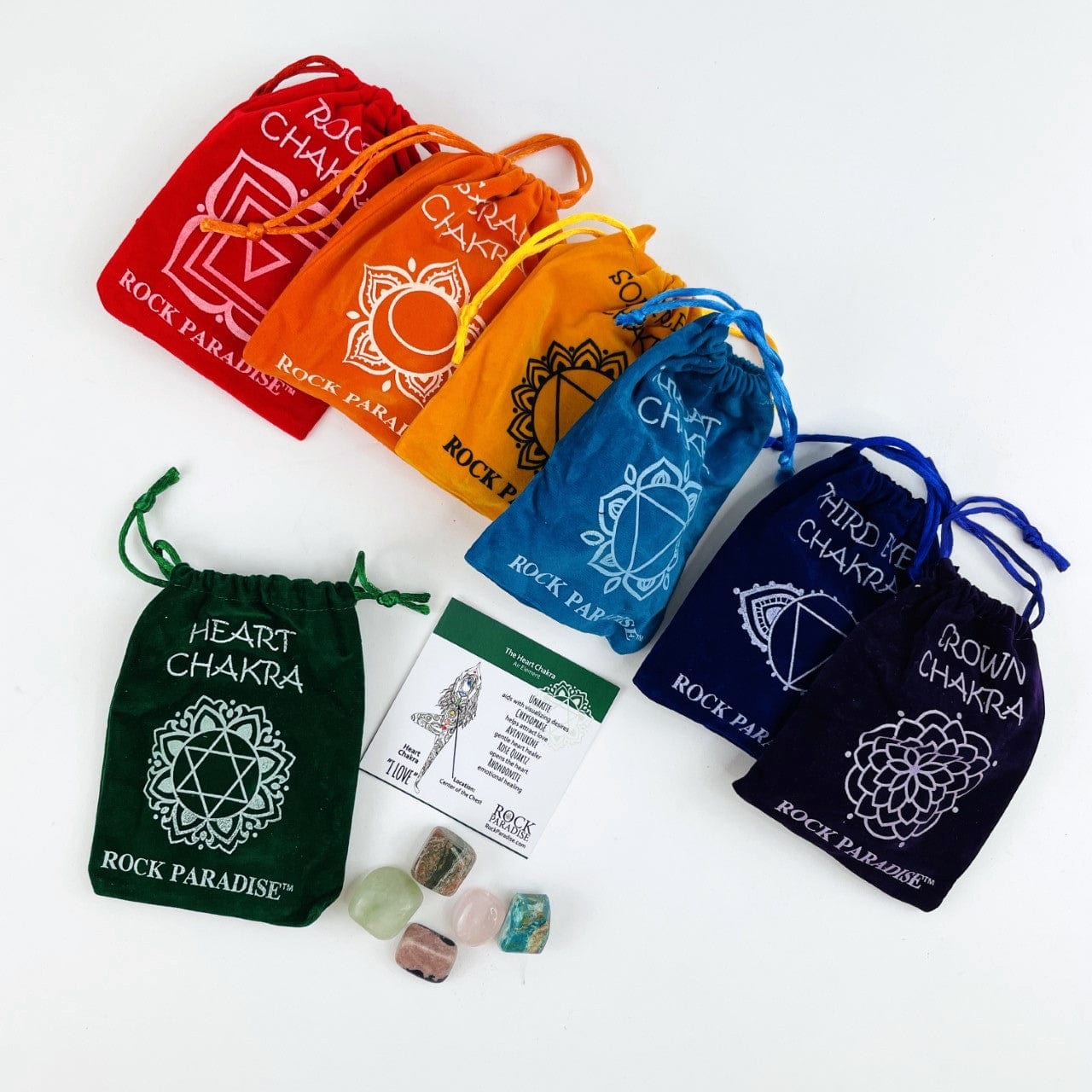 The Heart Chakra Set opened up with the information card and tumbled stones beside and all the other pouches behind