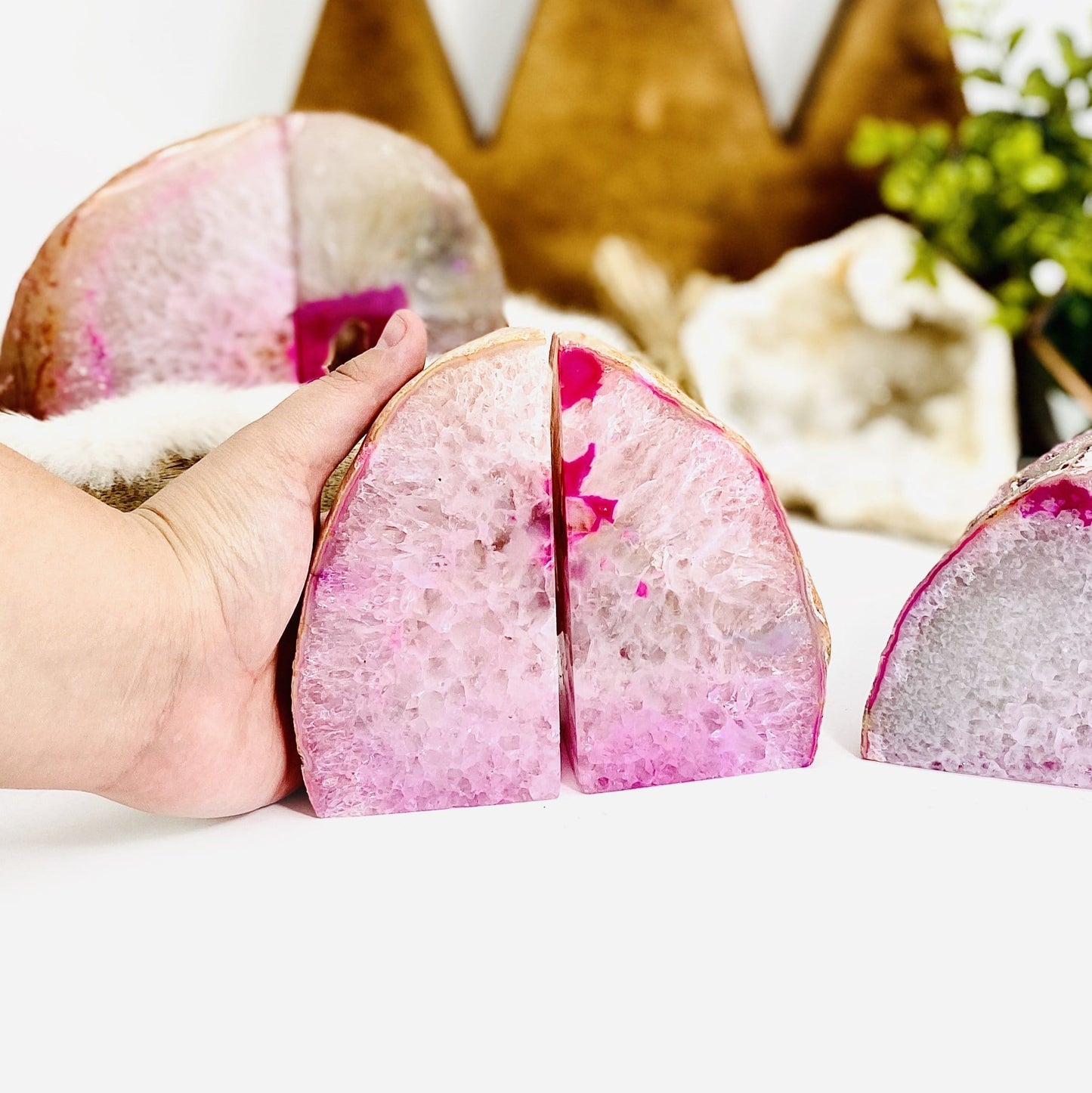 Frontal view of Pink Agate Geode Bookend Pair , hand placed behind left one for size reference.