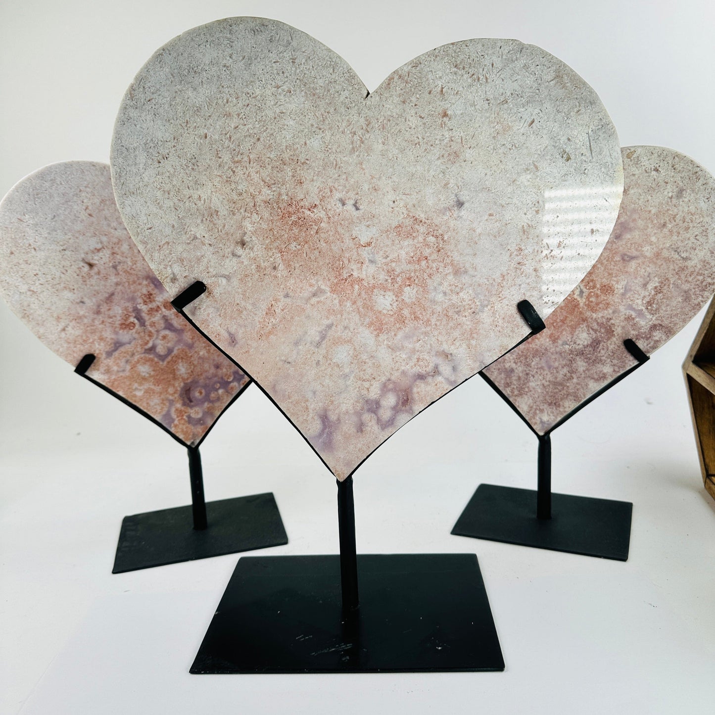 pink amethyst heart on metal stand with decorations in the background