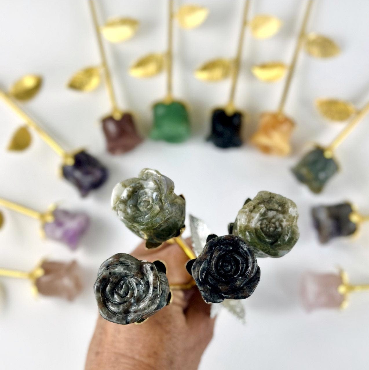Crystal Rose - Carved Stones up close and others laid out behind on table