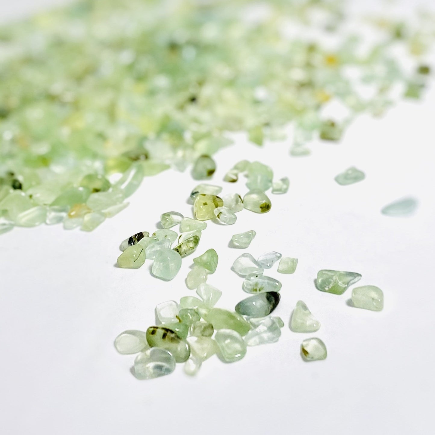 close up green prehnite chips on a white background