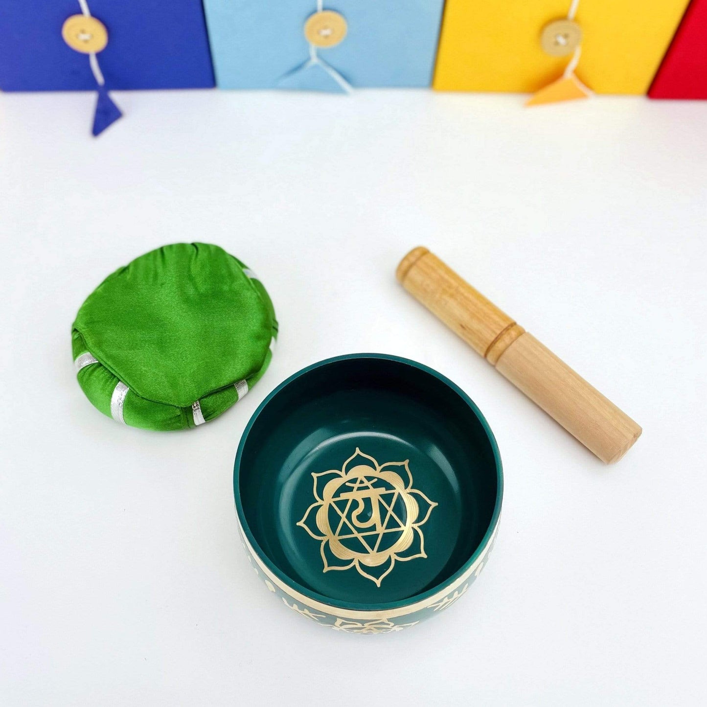Brass Tibetan Heart Chakra Singing Bowl shot from above beside a pillow and a mallet