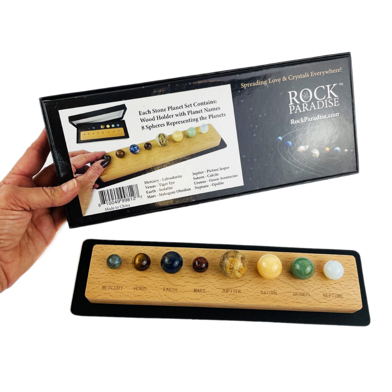 Gemstones planet box with a mat and wood base with all the stone planets in place a hand showing the back of the box
