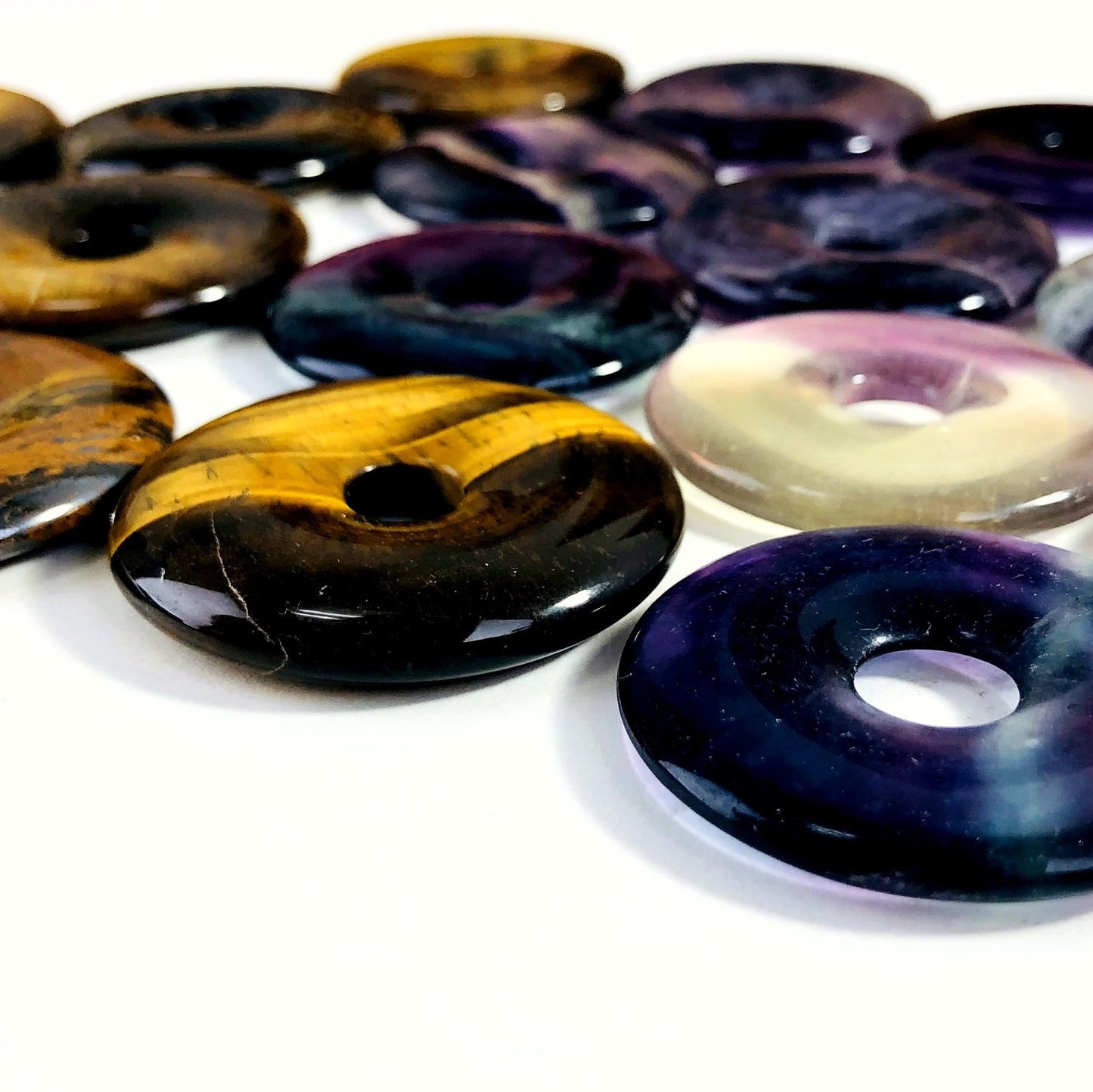 angled shot of donut shaped polished stones on white background