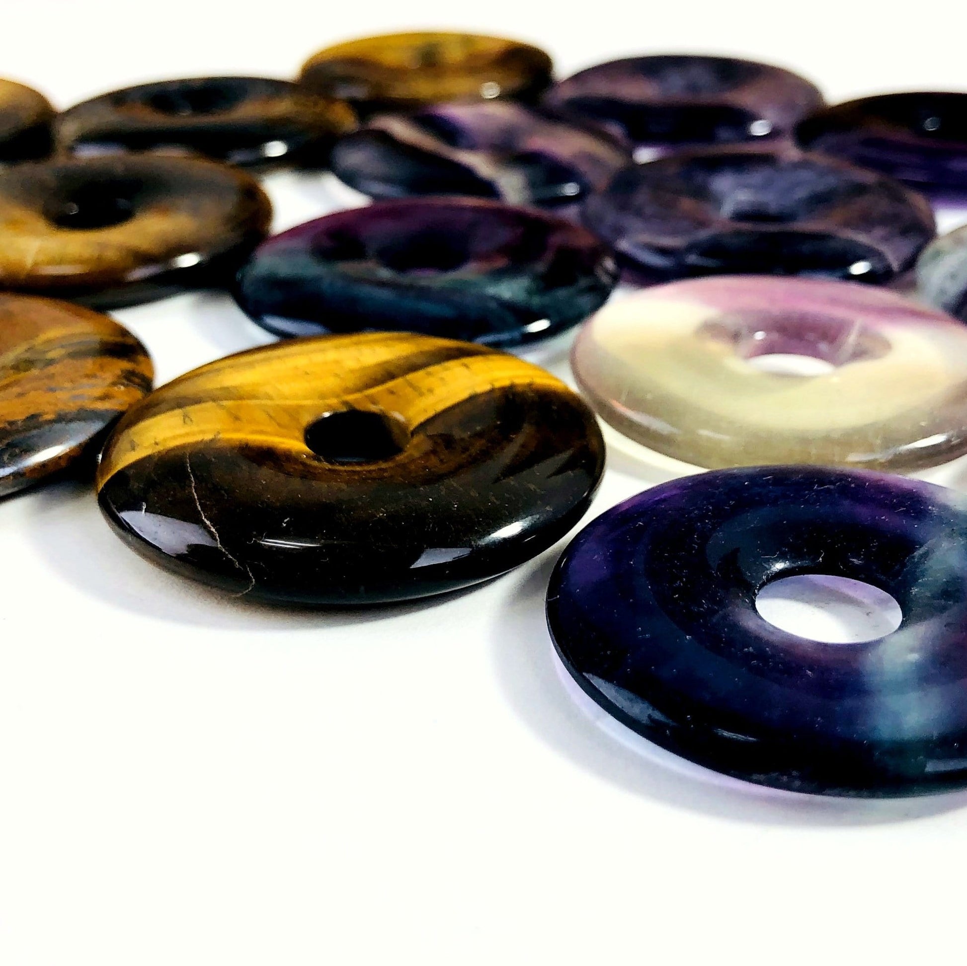 angled shot of donut shaped polished stones on white background