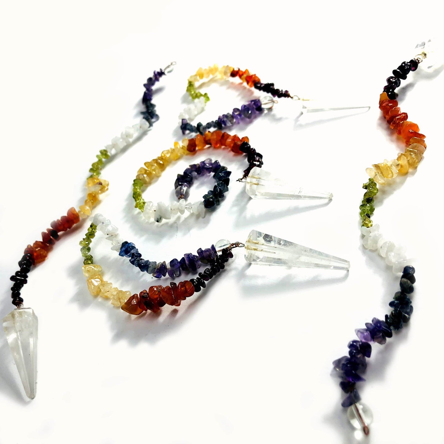 Crystal Quartz Pendulum with Chakra Beads  - on a table