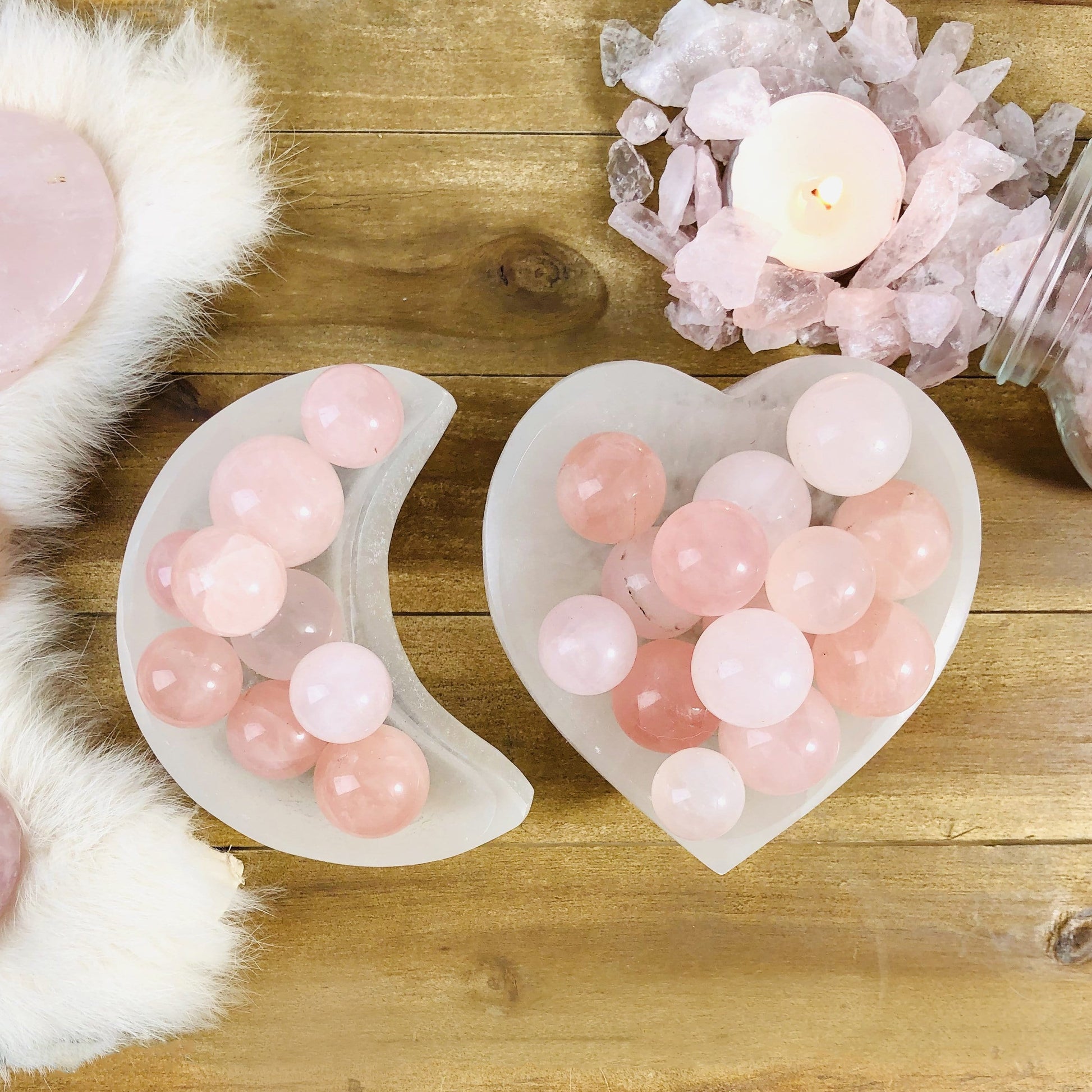 two selenite bowls filled with rose quartz spheres