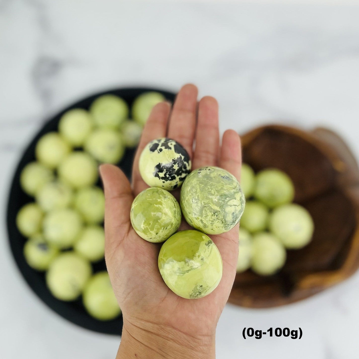 four 0g-100g serpentine polished spheres in hand for size reference and possible variations