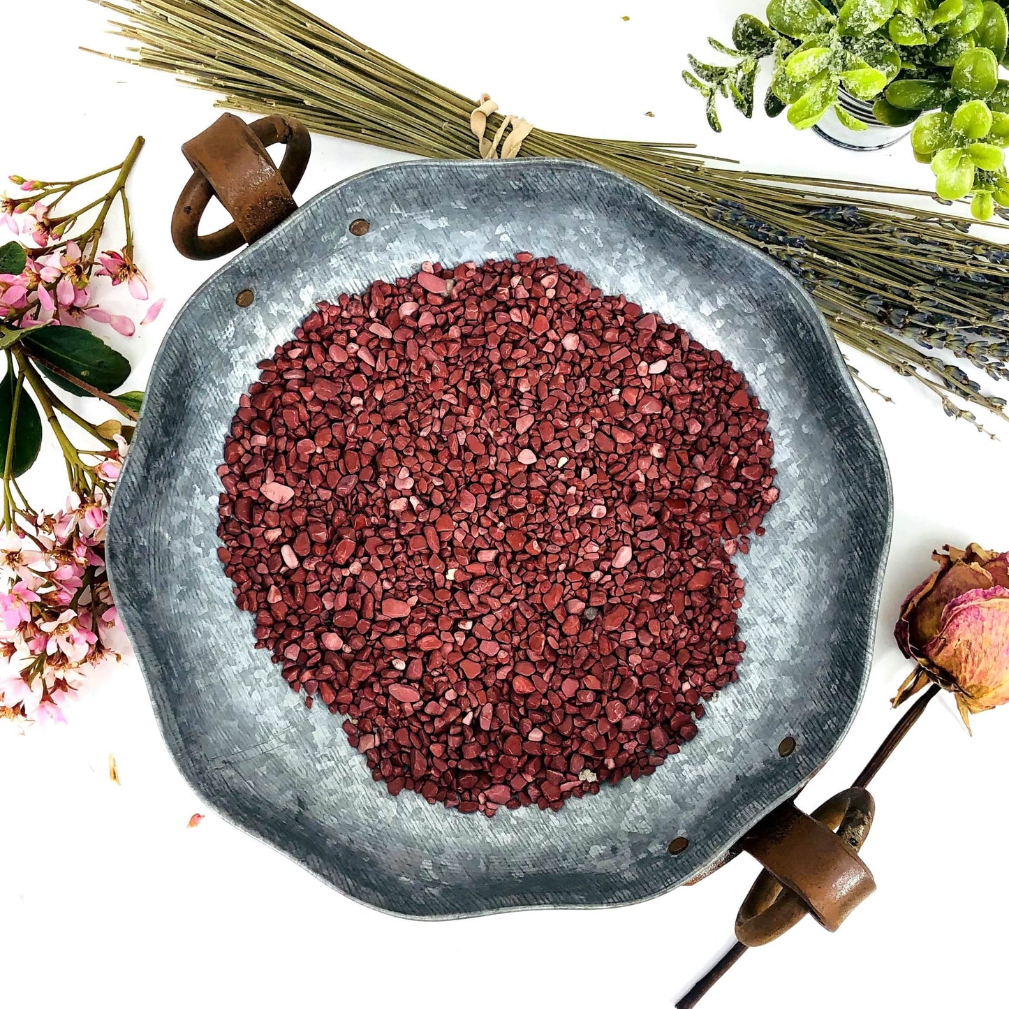 Bowl filled with Red Jasper Chips with dried flowers surrounding it