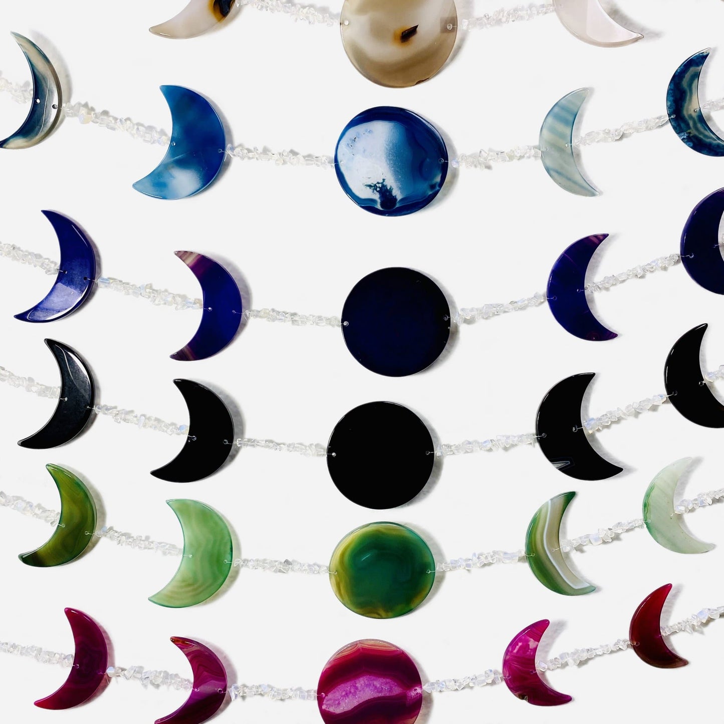 Close up image of moon phase wall hangings on a white background