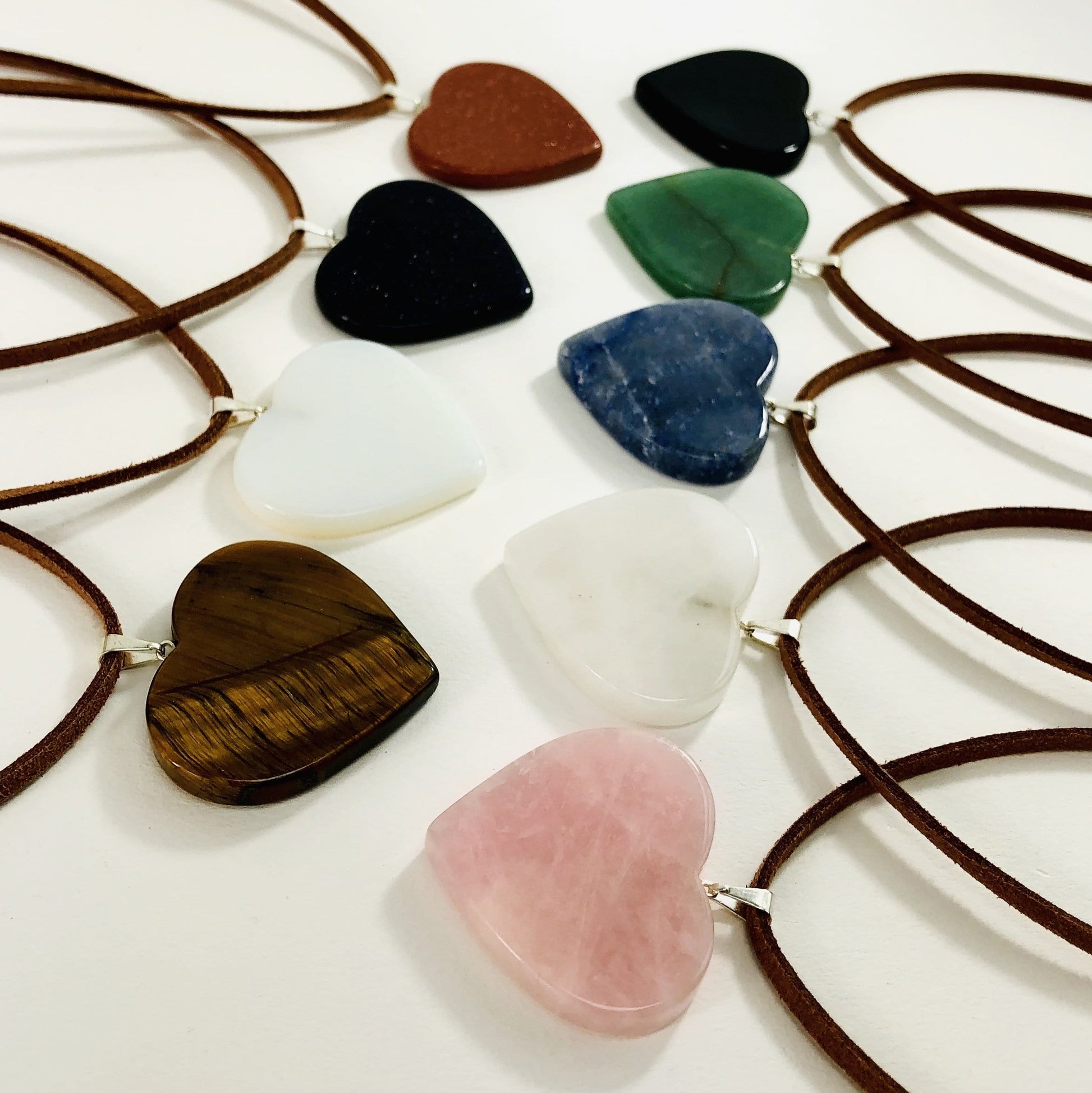 side shot of multiple heart slice pendants with silver toned bail with string on them to show as a neckless
