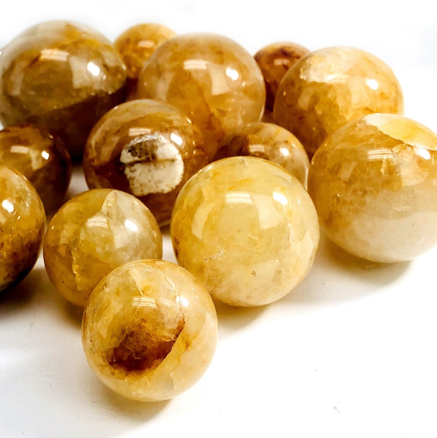 angled shot of golden healer polished spheres on white background
