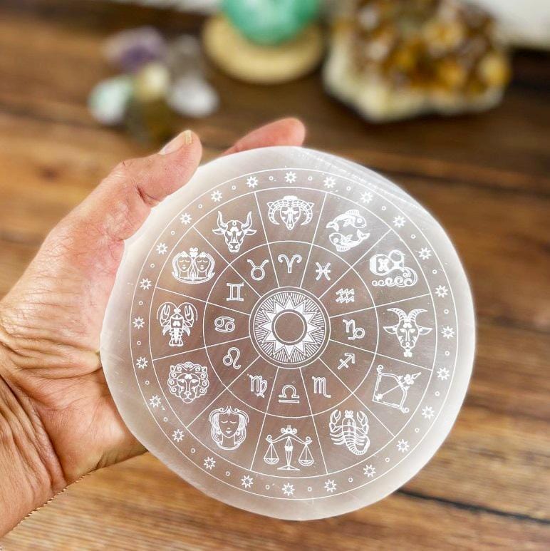 selenite zodiac engraved charging plate in hand for size reference