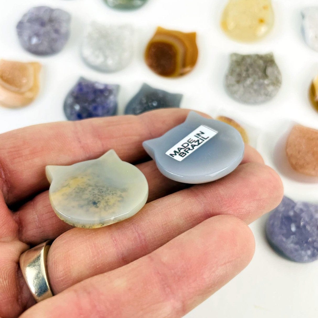 The backside of an agate druzy cat head in a hand.