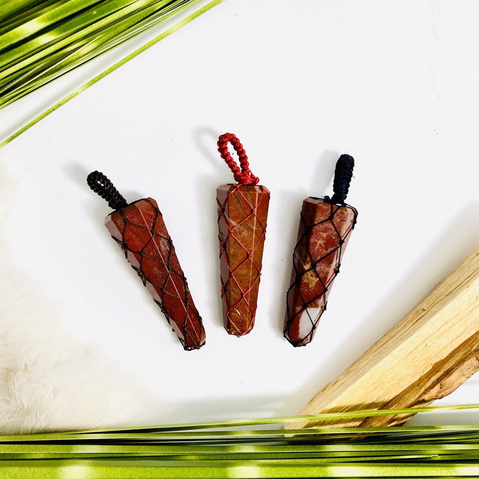3 Red Jasper Points - Netted Pendants with dried plants on white background