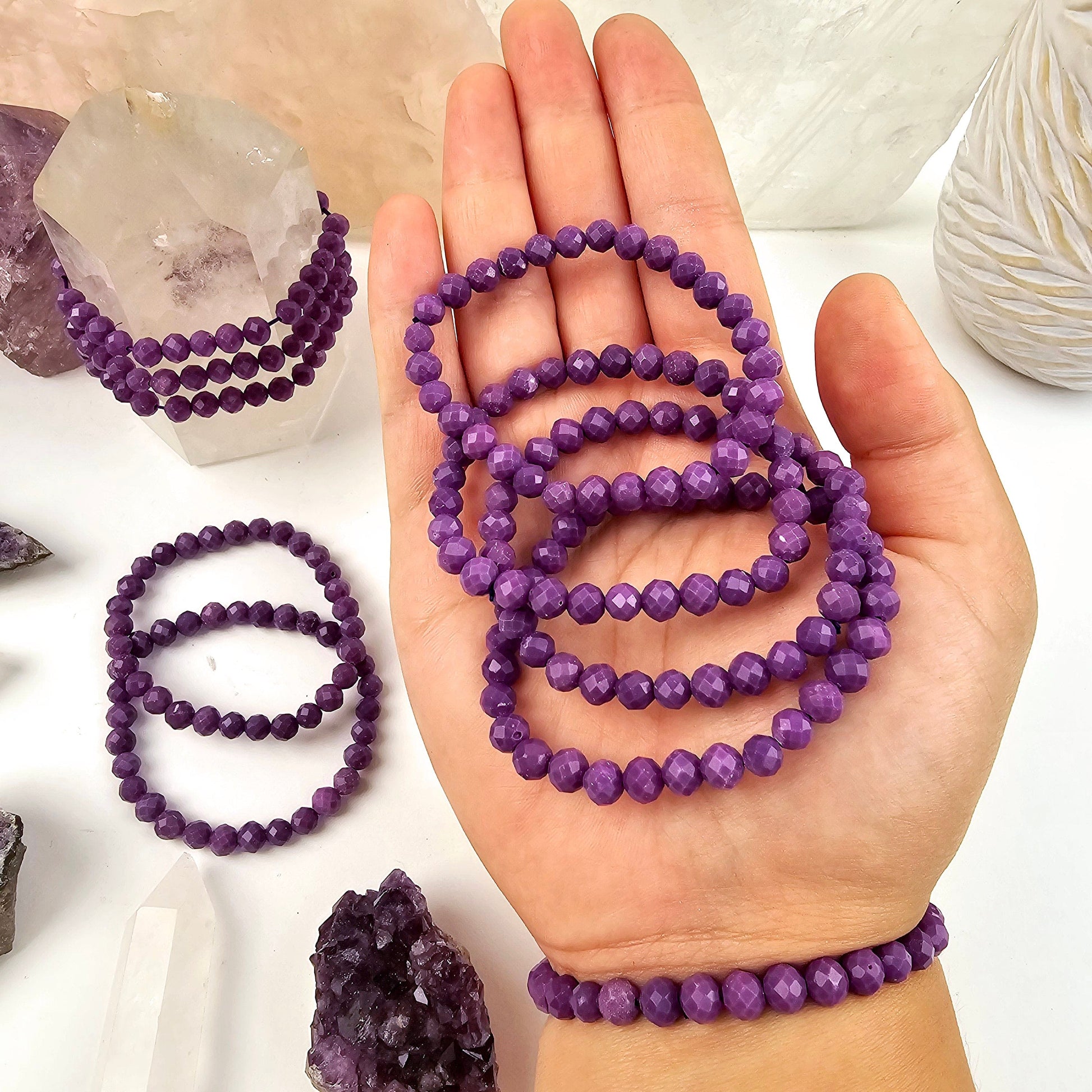 Phosphosiderite Faceted Round Bead Bracelet - 6mm - 4 bracelets in hand, 1 on wrist, several in the background