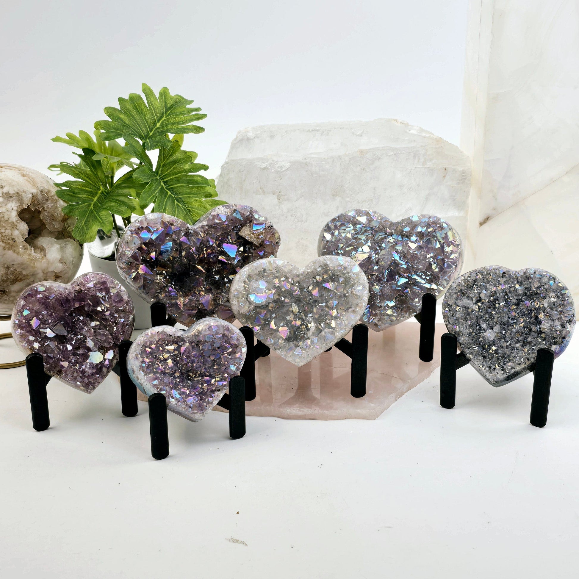 Angel Aura Amethyst Crystal Heart on Metal Tripod Stand - six shown on stone platter with props and plants in the background