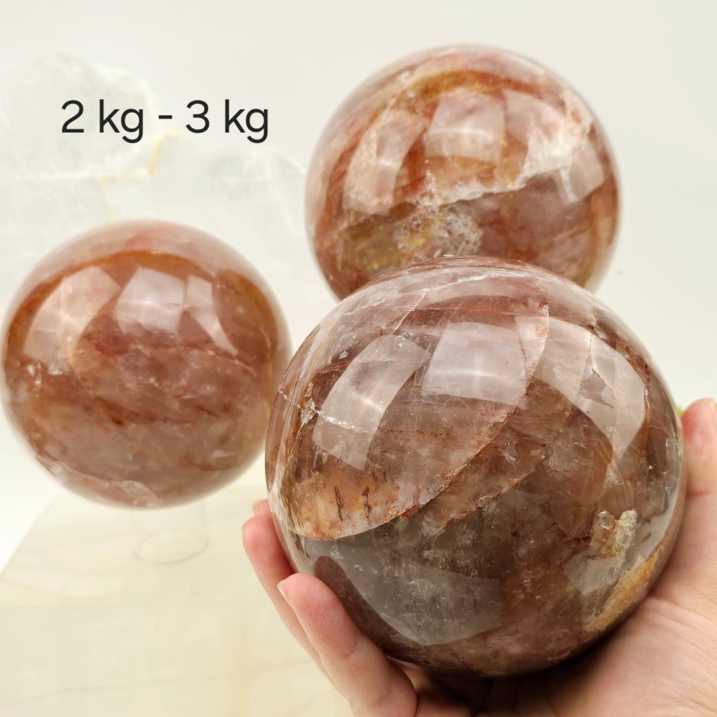 Guava Quartz Polished Crystal Sphere - By Weight variant 2 kg - 3 kg labeled one in hand for size reference