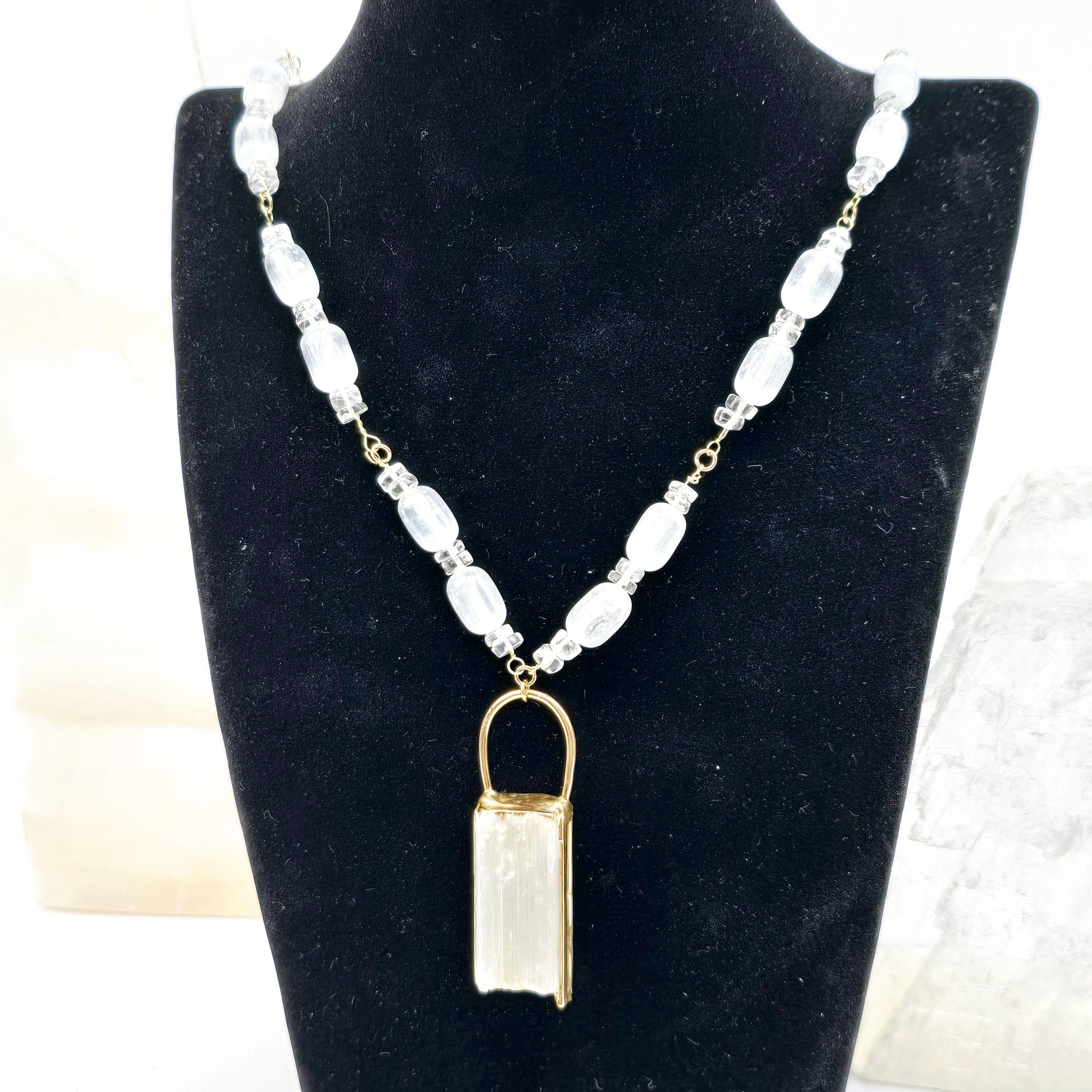Selenite and Crystal Quartz Gold Filled Crystal Necklace - Handmade - One-of-a-Kind on necklace stand with props in the background