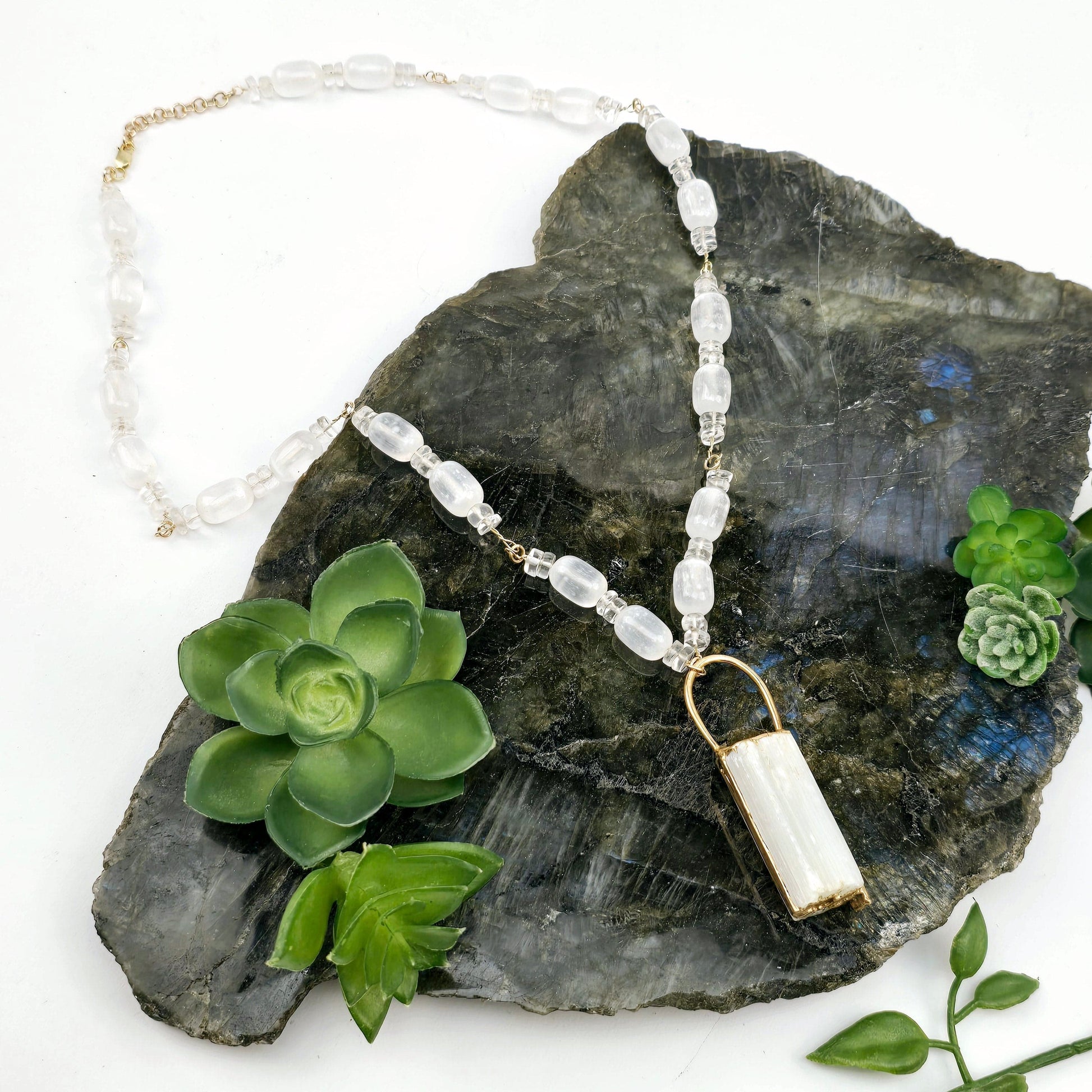 Selenite and Crystal Quartz Gold Filled Crystal Necklace - Handmade - One-of-a-Kind on stone platter with plants