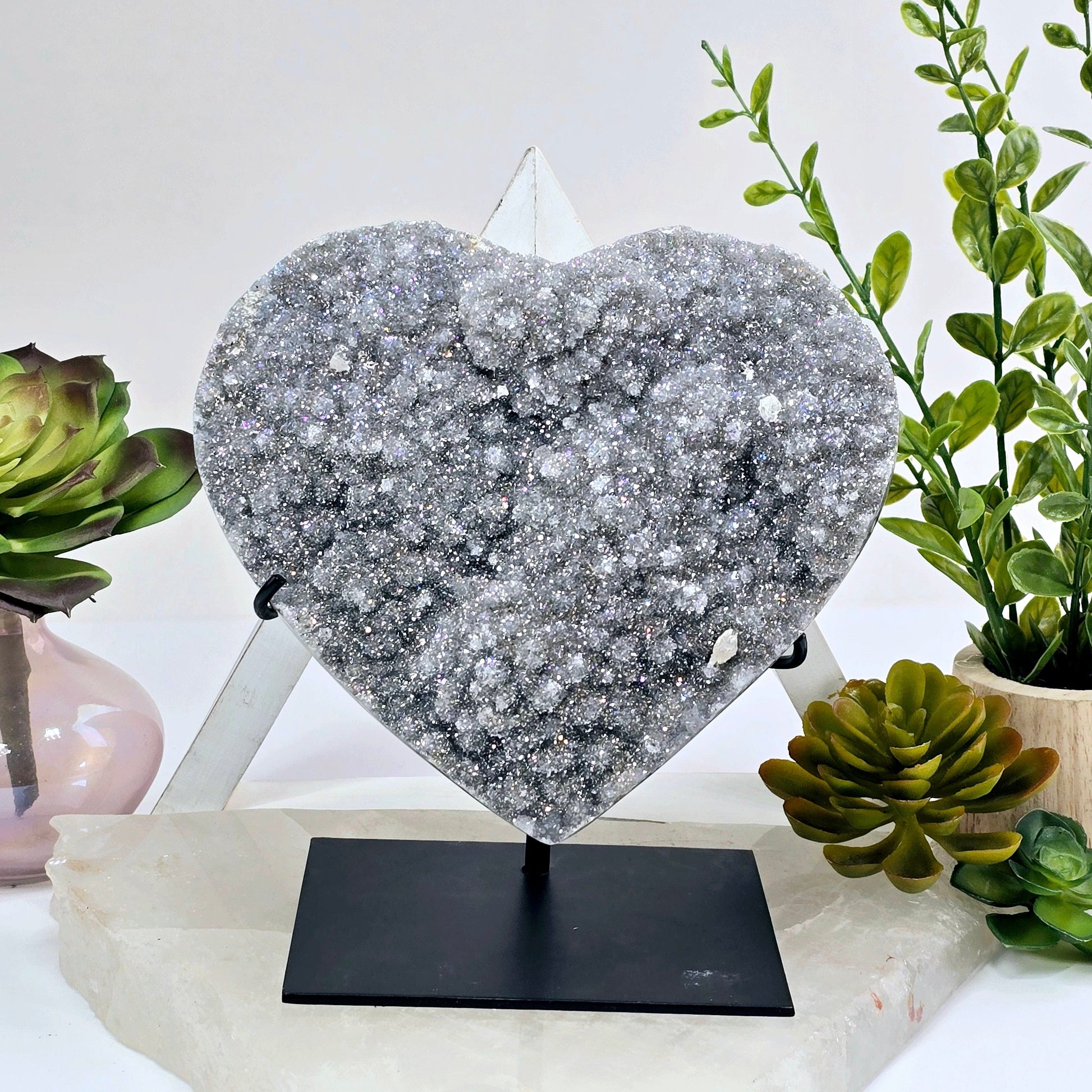 Angel Aura Amethyst Druzy Crystal Heart on Stand Valentine's Day Gift front view with props and plants in the background