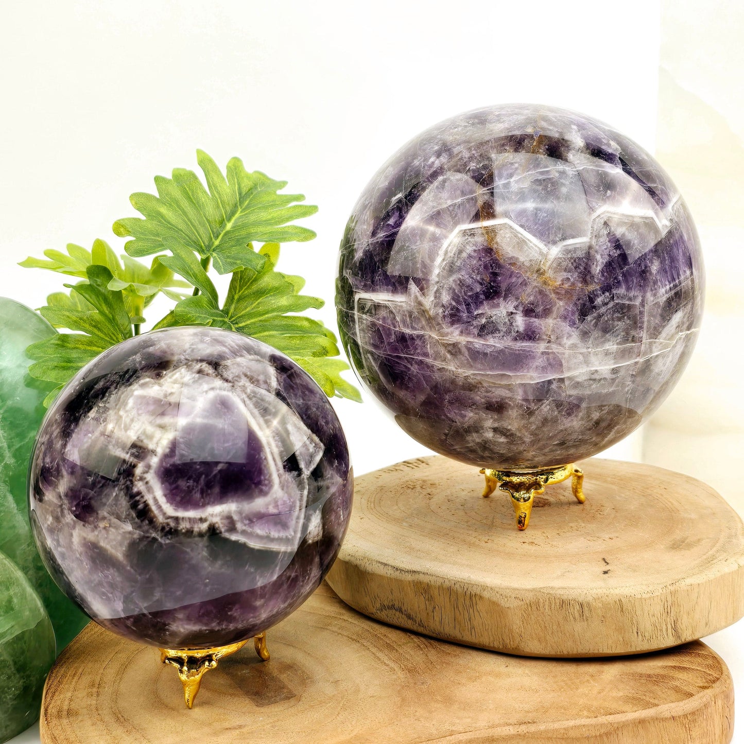 Chevron Amethyst Crystal Sphere YOU CHOOSE #1 both variants on sphere stands on wooden coasters with plants and props in the background