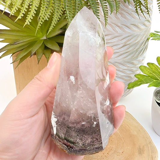 Lodalite Polished Crystal One-of-a-Kind #11 in hand for size reference with props and plants in the background