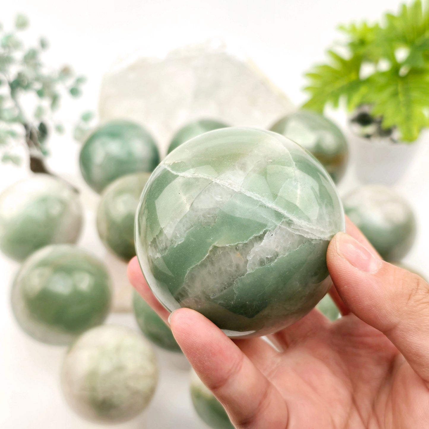 Green and White Quartz Crystal Sphere - You Choose #1 one variant in hand for size reference with other variants in the background