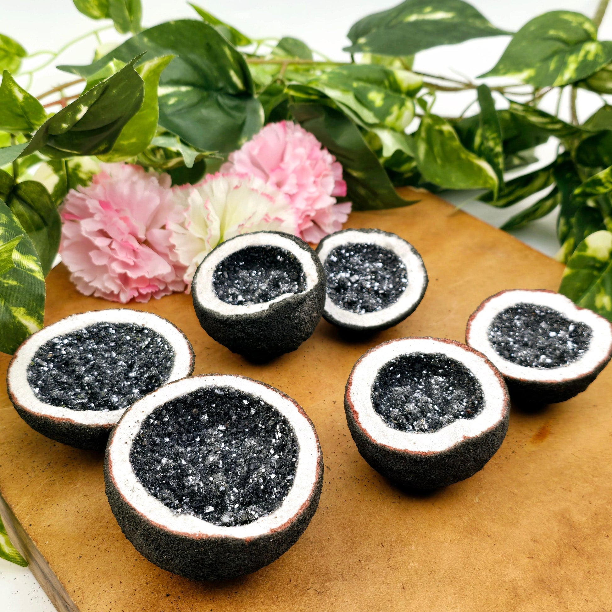 Galena Crystal Geode Pair from Morocco - Manmade side view with plants and props in the background on wooden surface
