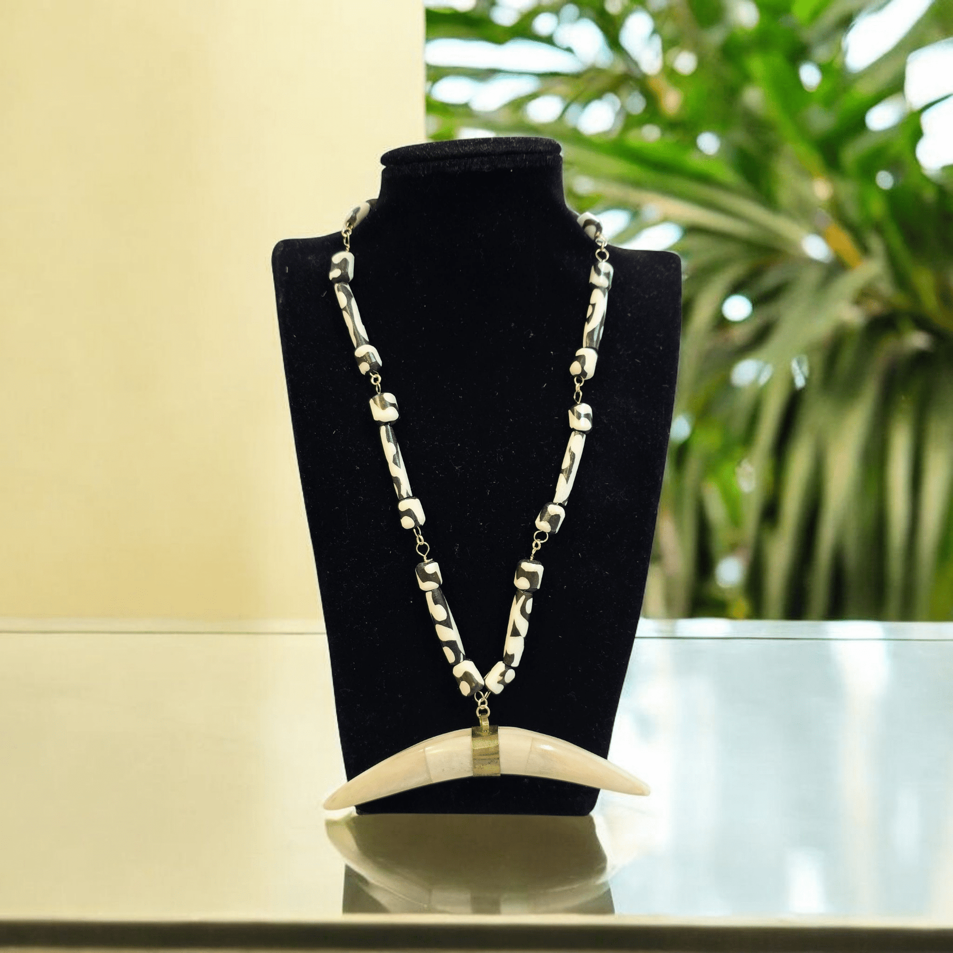 Batik Bone Beaded Gold Fill Necklace with Brass Buffalo Bone Pendant - Fair Trade from Africa and Nepal - Handmade on necklace stand 