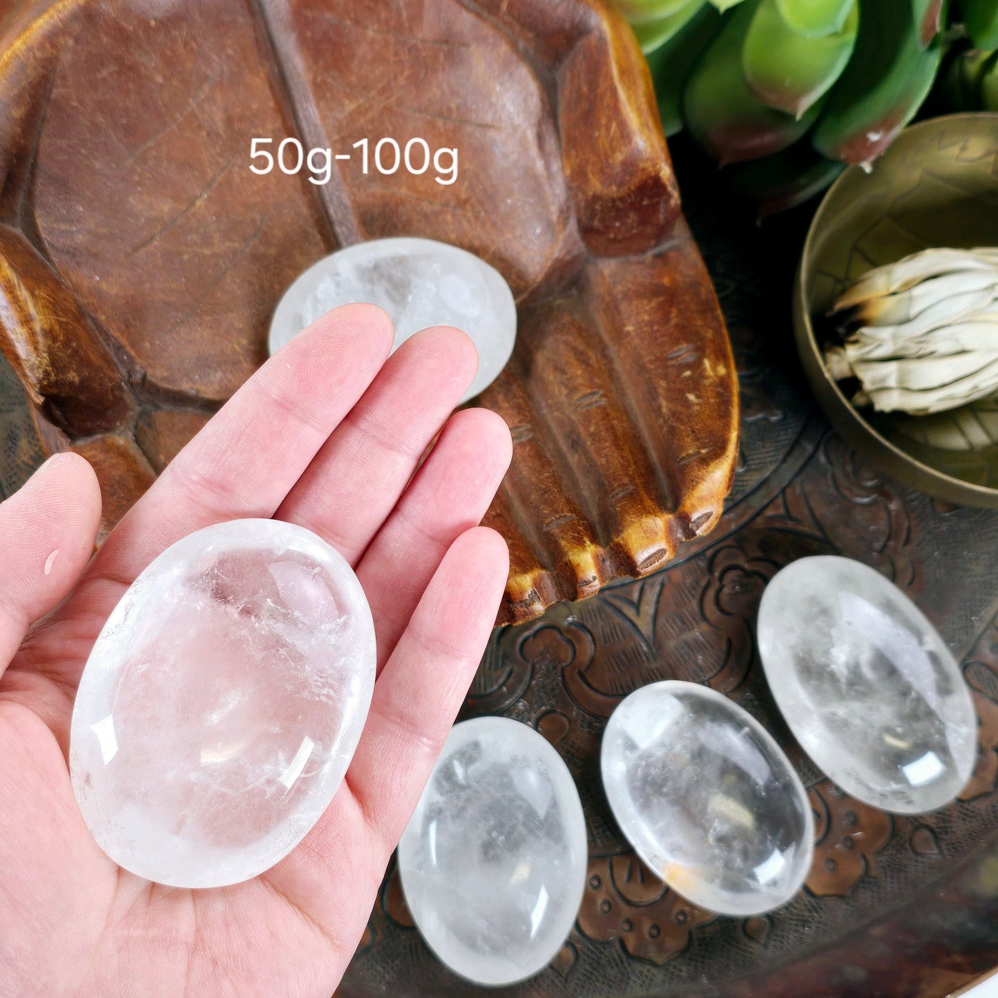 Crystal Quartz Palm Stone - By Weight 50g-100g variant in hand for size reference labeled