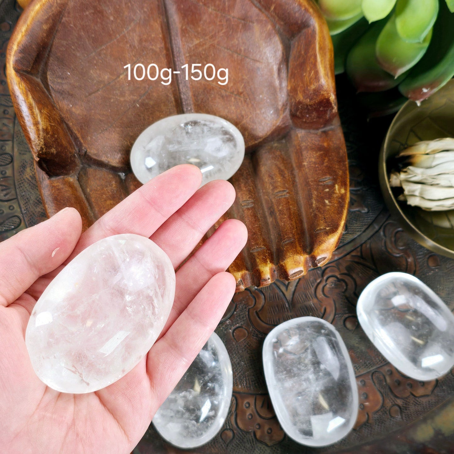 Crystal Quartz Palm Stone - By Weight 100g-150g variant in hand for size reference labeled 