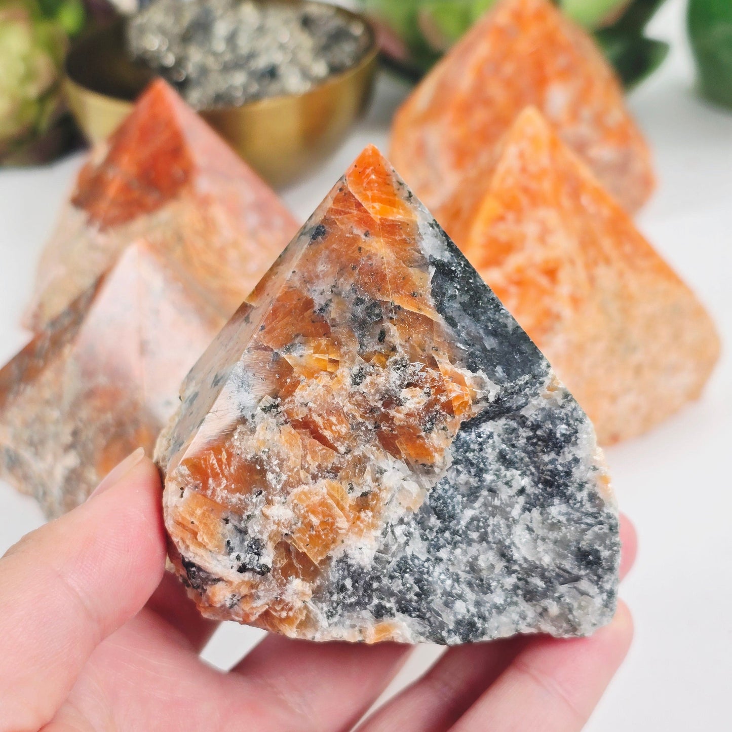 Orchid Calcite Semi Polished Crystal Point - You Choose one variant in hand for size reference with other variants in the background with props and plants