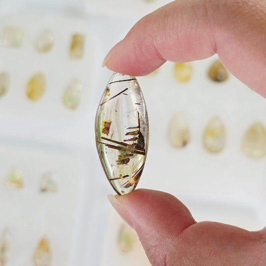 Rutilated Quartz Crystal Pendant - You Choose - variant 34 in hand for size reference with other variants in the backgrond