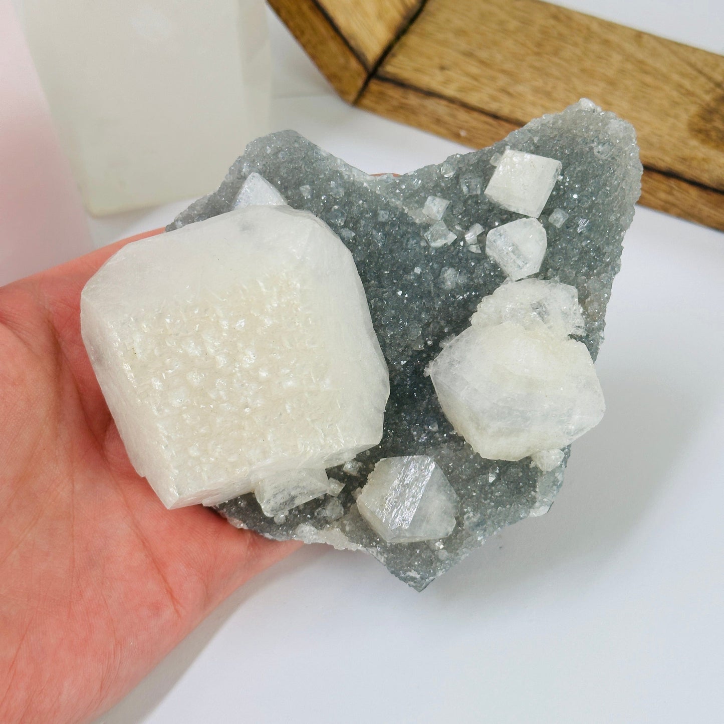 zeolite apophyllite on matrix with decorations in the background