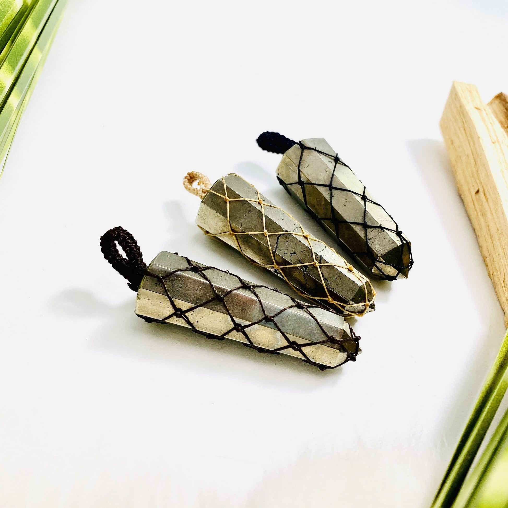 3 pyrite netted pendants on a table