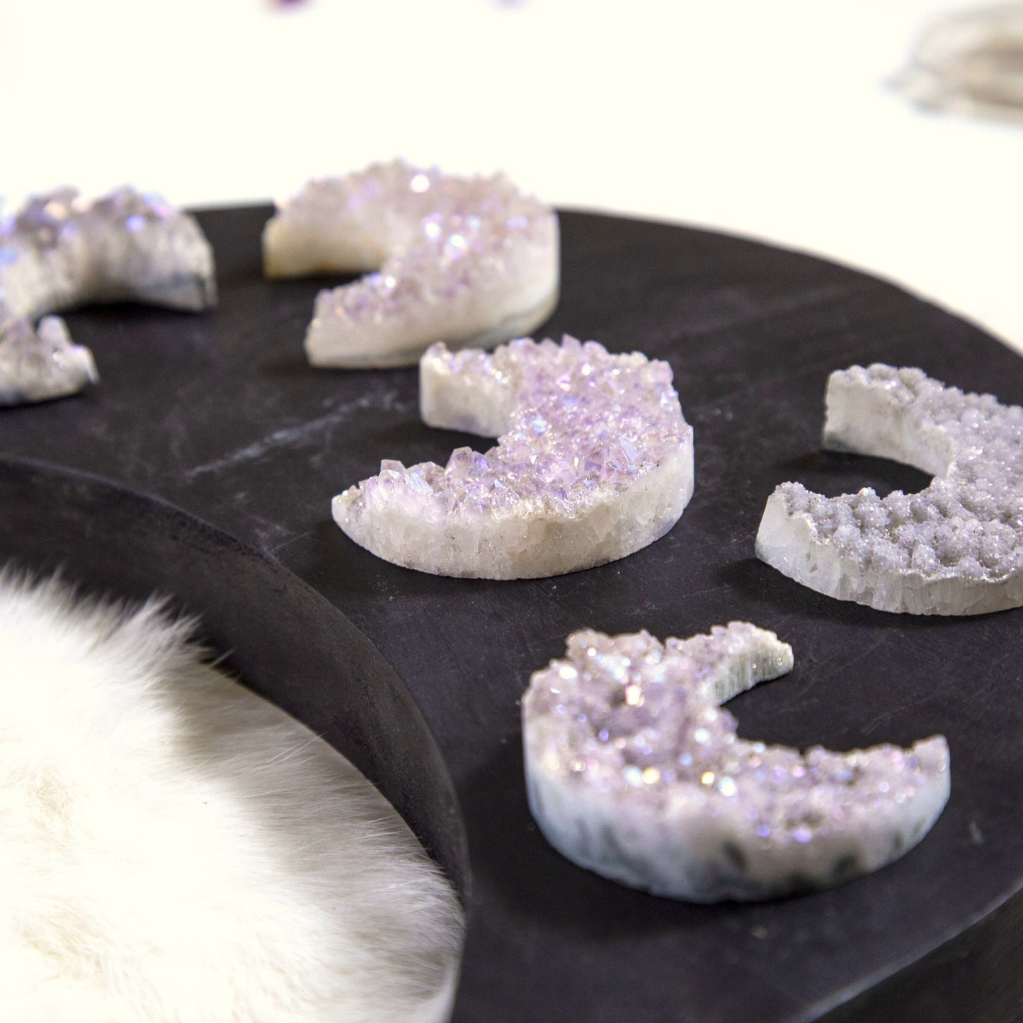 side view of moon shaped titanium druzy cabochon on moon shaped platter