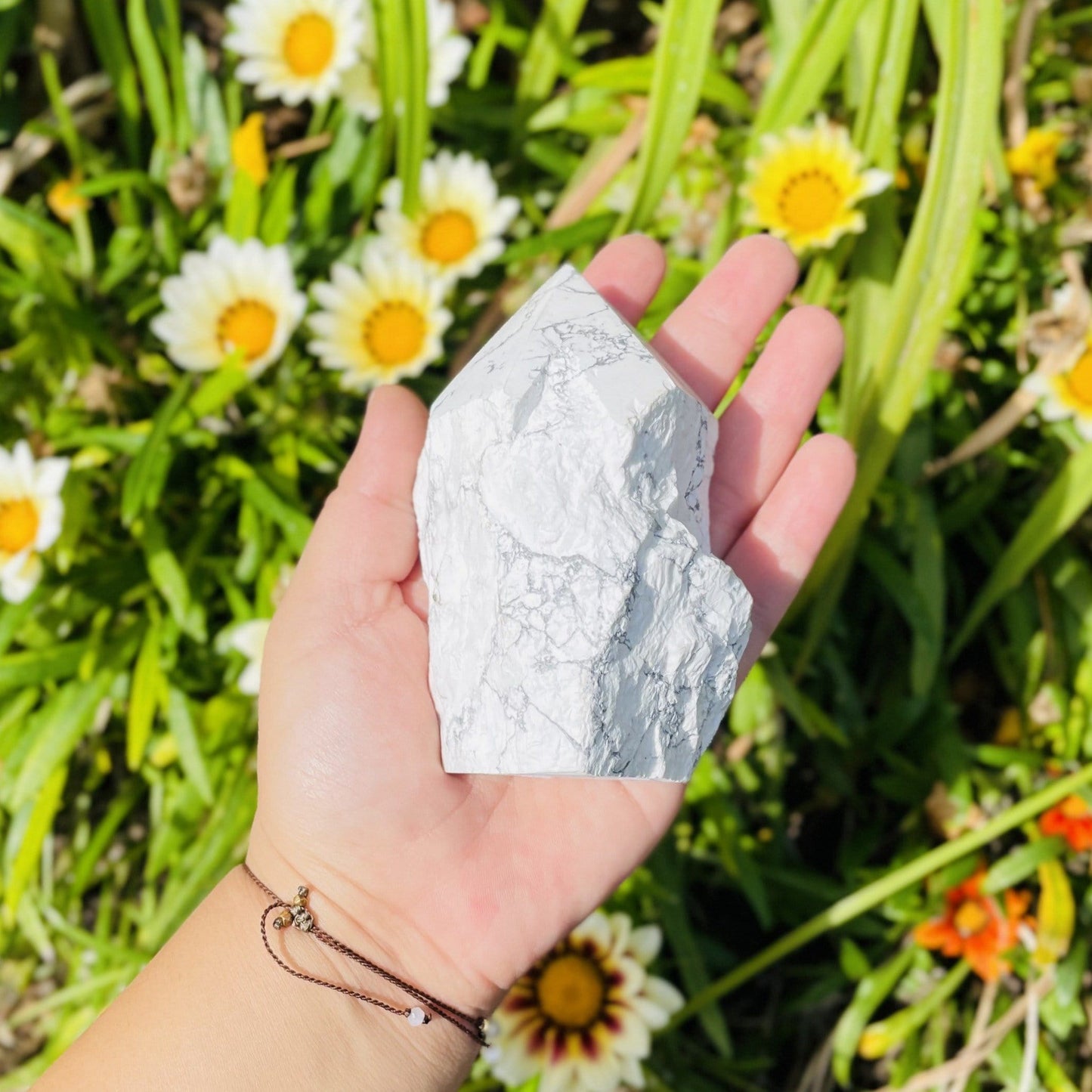 white howlite point with the top polished and the bottom left rough.  Held in a woman's hand.