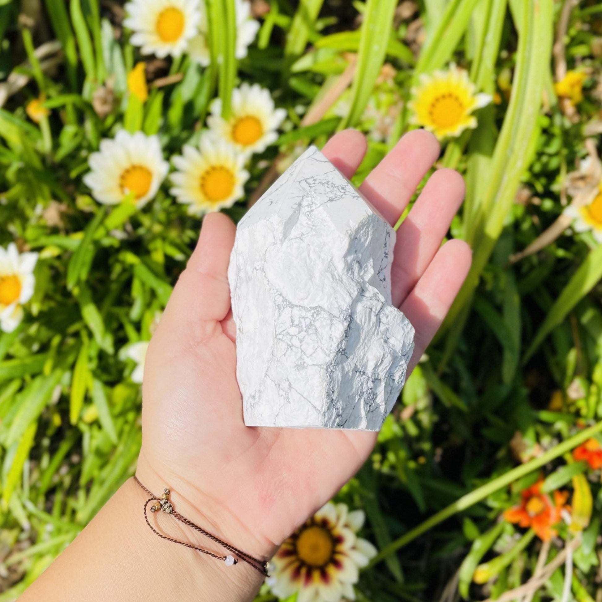 white howlite point with the top polished and the bottom left rough.  Held in a woman's hand.
