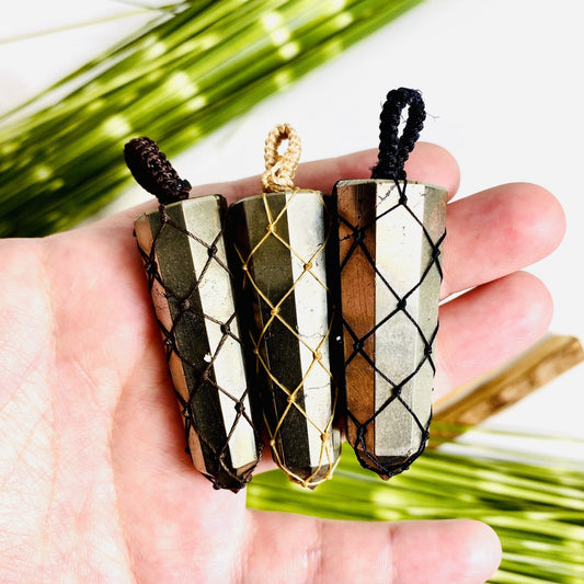 3 pyrite pendants with netting in a hand