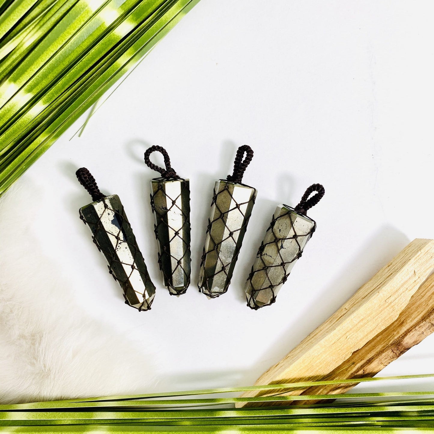 4 netted pyrite pendants on a table