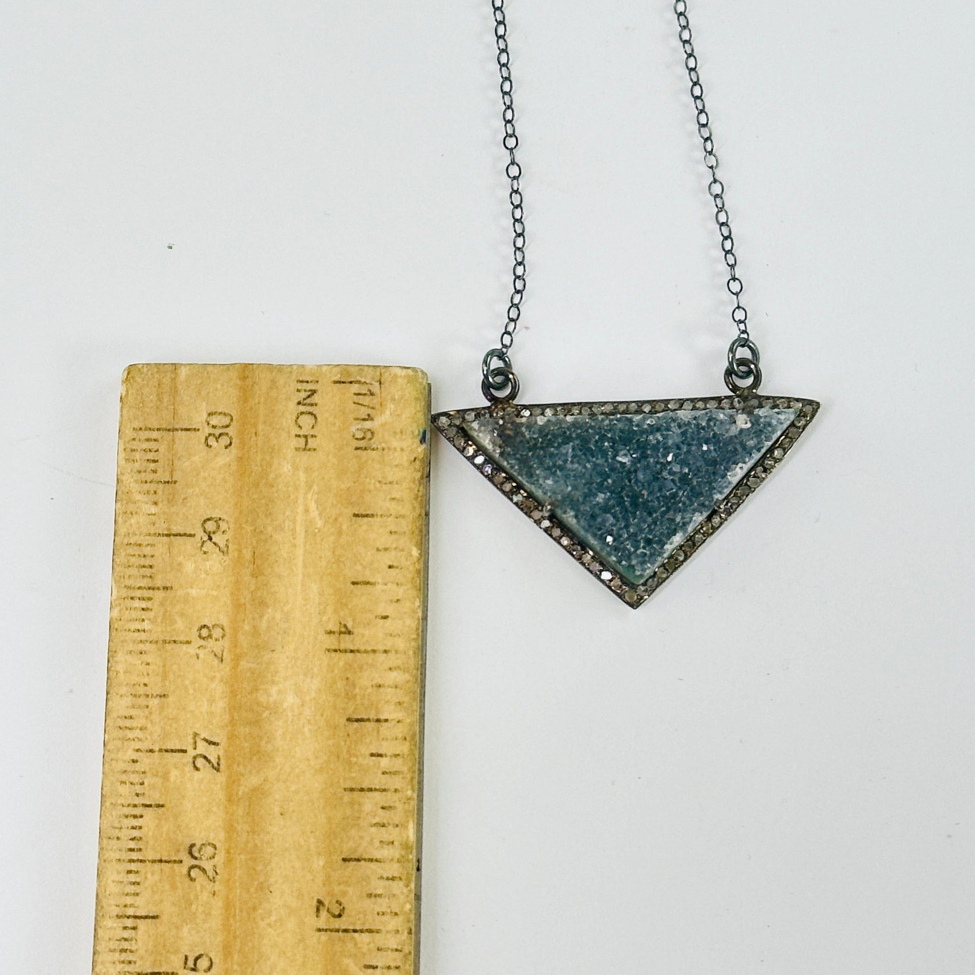 druzy pendant necklace next to a ruler for size reference