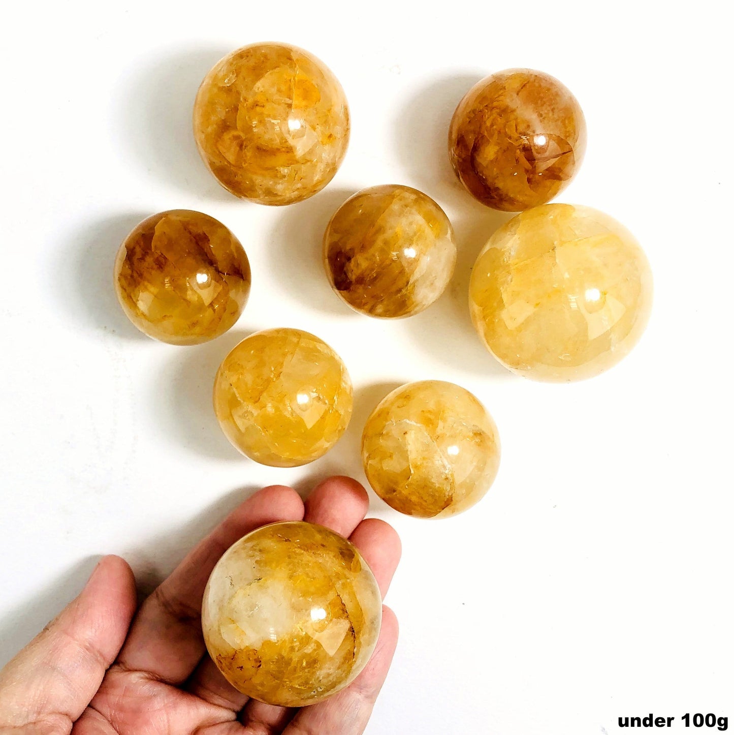 golden healer polished spheres under 100g on white background