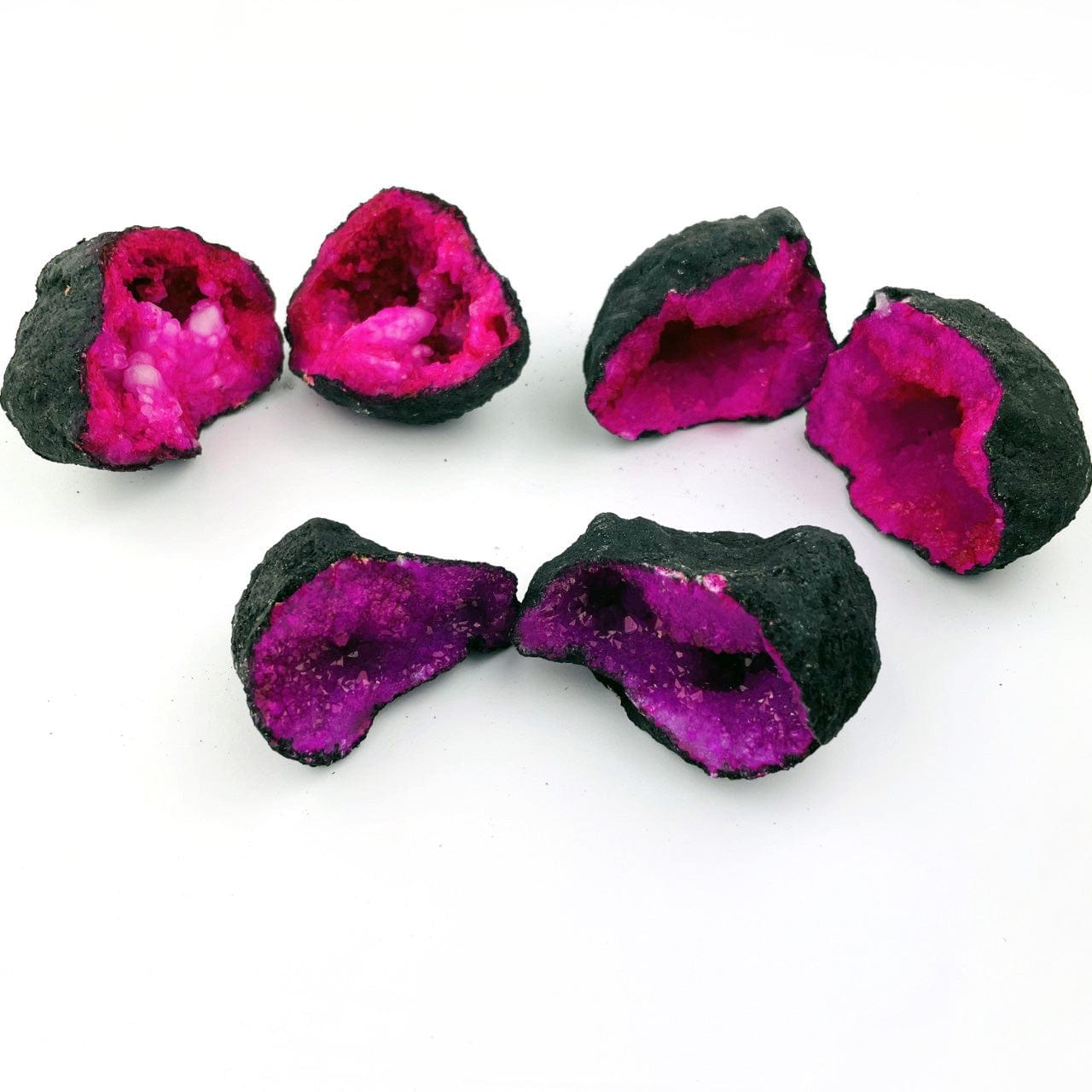 3 Hot Pink Color Dyed opened Geodes on a table